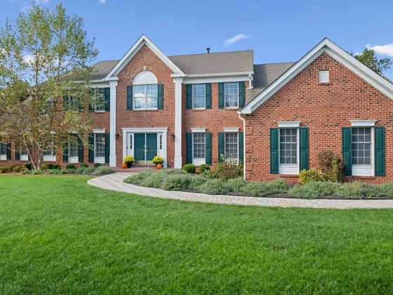 The front yard and entrance of a sprawling New Jersey brick house.