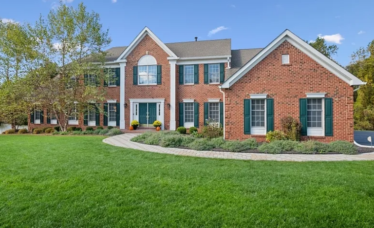 The front yard and entrance of a sprawling New Jersey brick house.