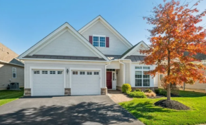 A modern single-family home in New Jersey, featuring a two-car garage and fall foliage.