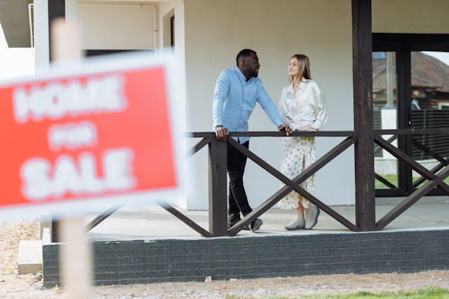 Two people in New Jersey are standing at a deck and discussing property documents or a settlement agreement.